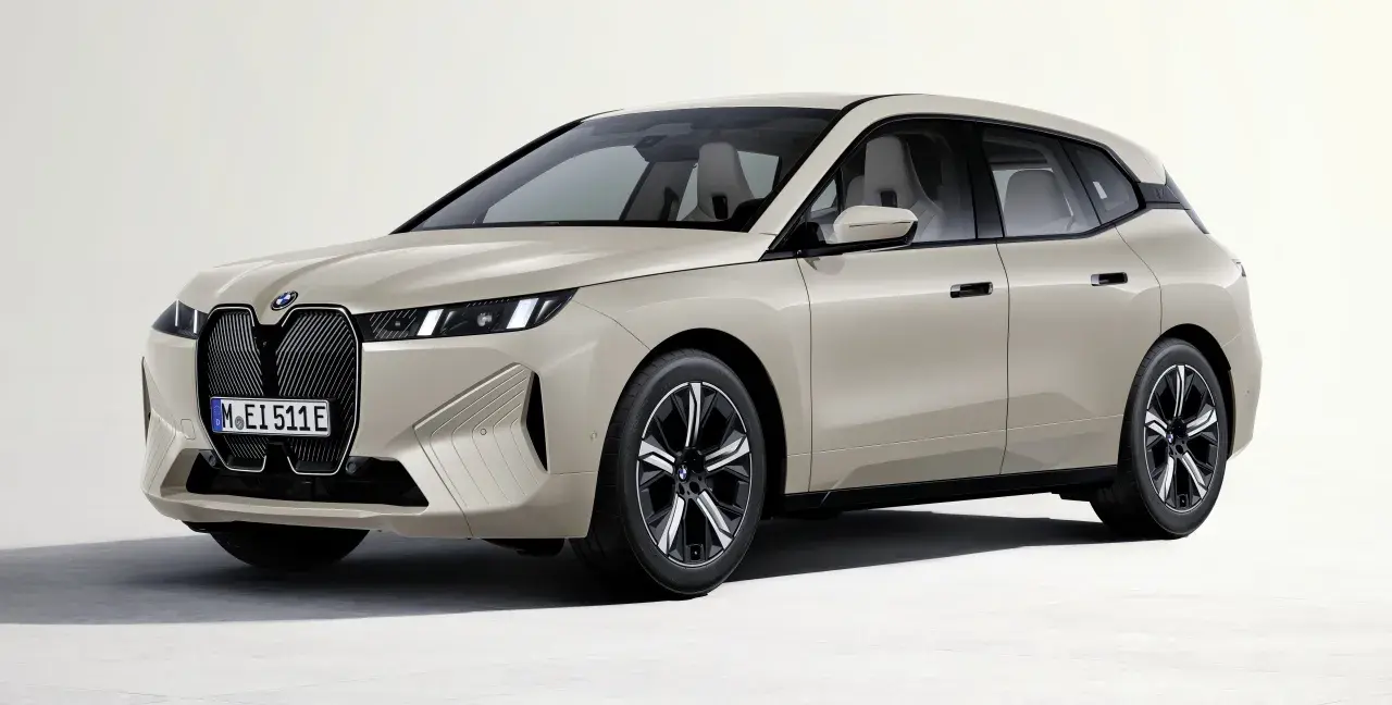Elegancki, beżowy BMW iX z nowoczesnym grillem i smukłymi światłami.