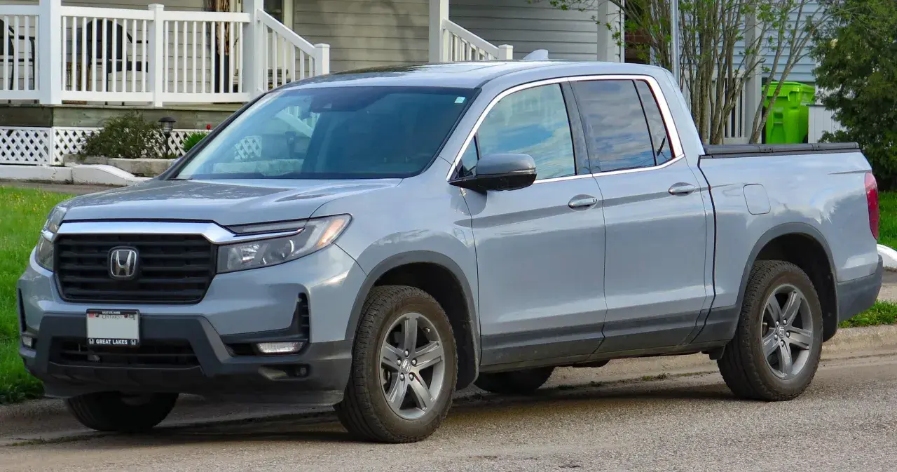 Szary Honda Ridgeline stoi przed domem.