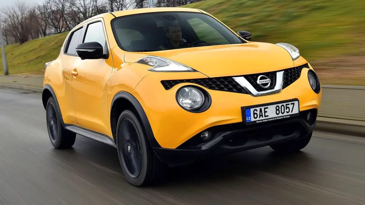 Żółty Nissan Juke 1.6 benzyna w ruchu ulicznym.