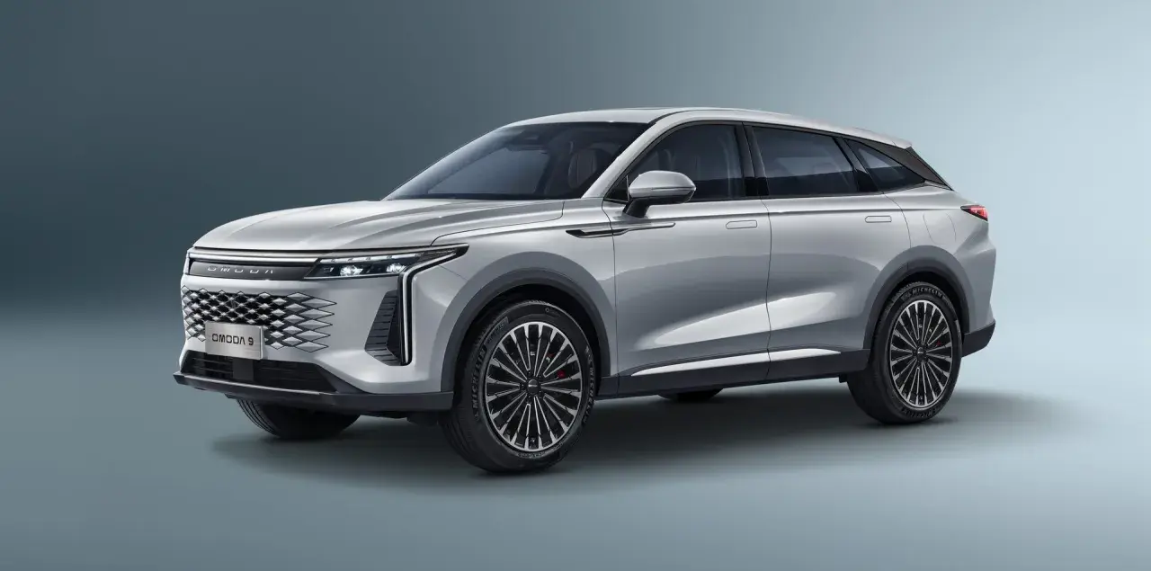 Srebrny OMODA 9 Super Hybrid z futurystycznym grillem i eleganckimi liniami nadwozia.
