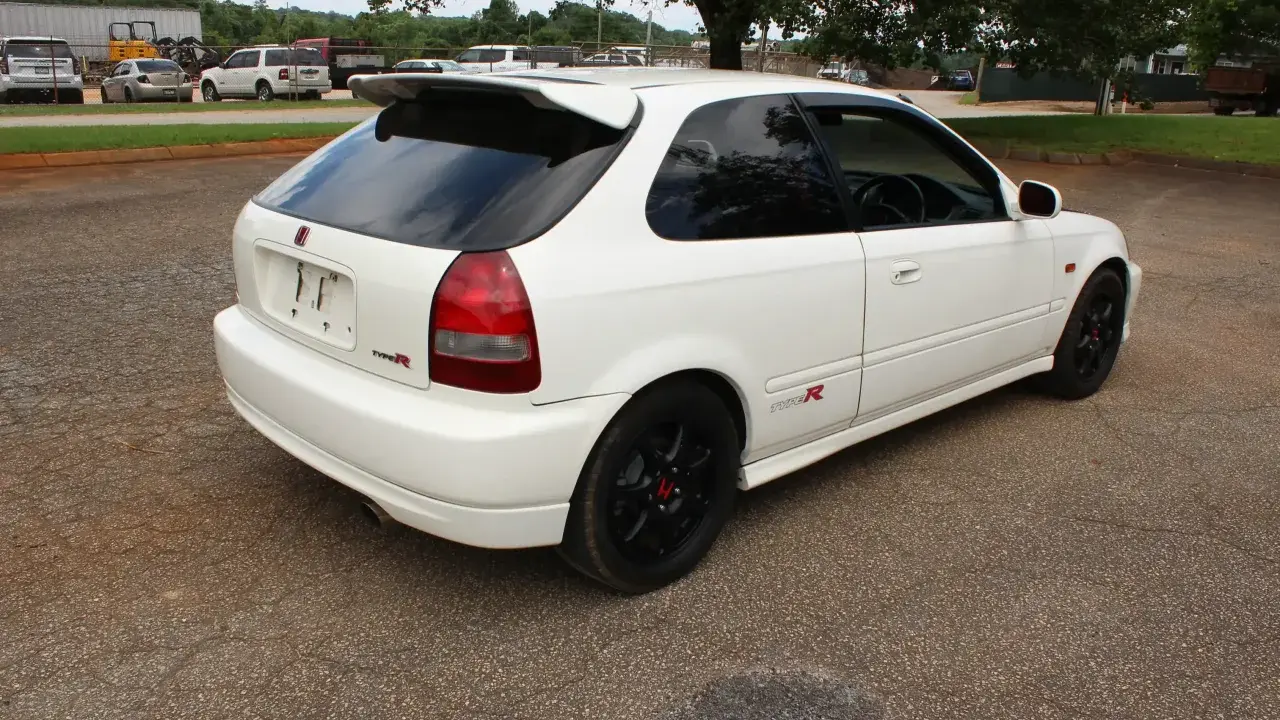 Białe Honda Civic EK9 Type R z czarnymi felgami i spojlerem, gotowe do jazdy.