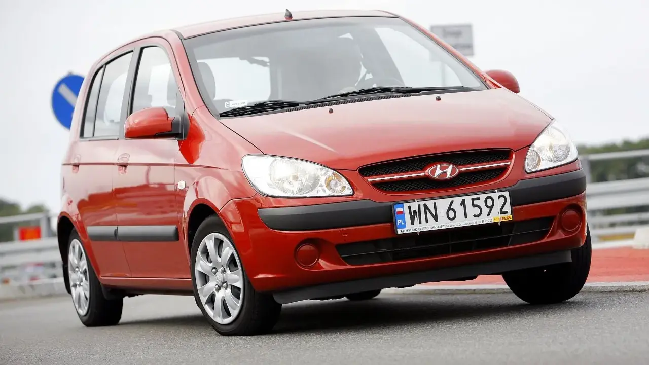 Czerwony Hyundai Getz 1.1 z polskimi tablicami WN 61592 na drodze.