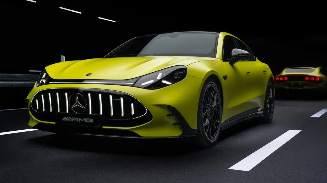 Jaskrawożółty Mercedes-AMG GT 63 z czarnym dachem i felgami, na ciemnym tle z białymi pasami drogowymi.