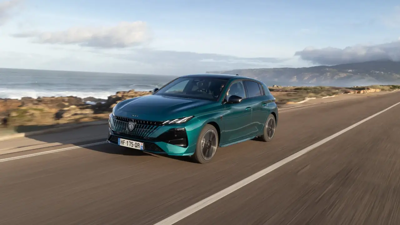 Zielony Peugeot 308 jedzie wzdłuż malowniczego wybrzeża.