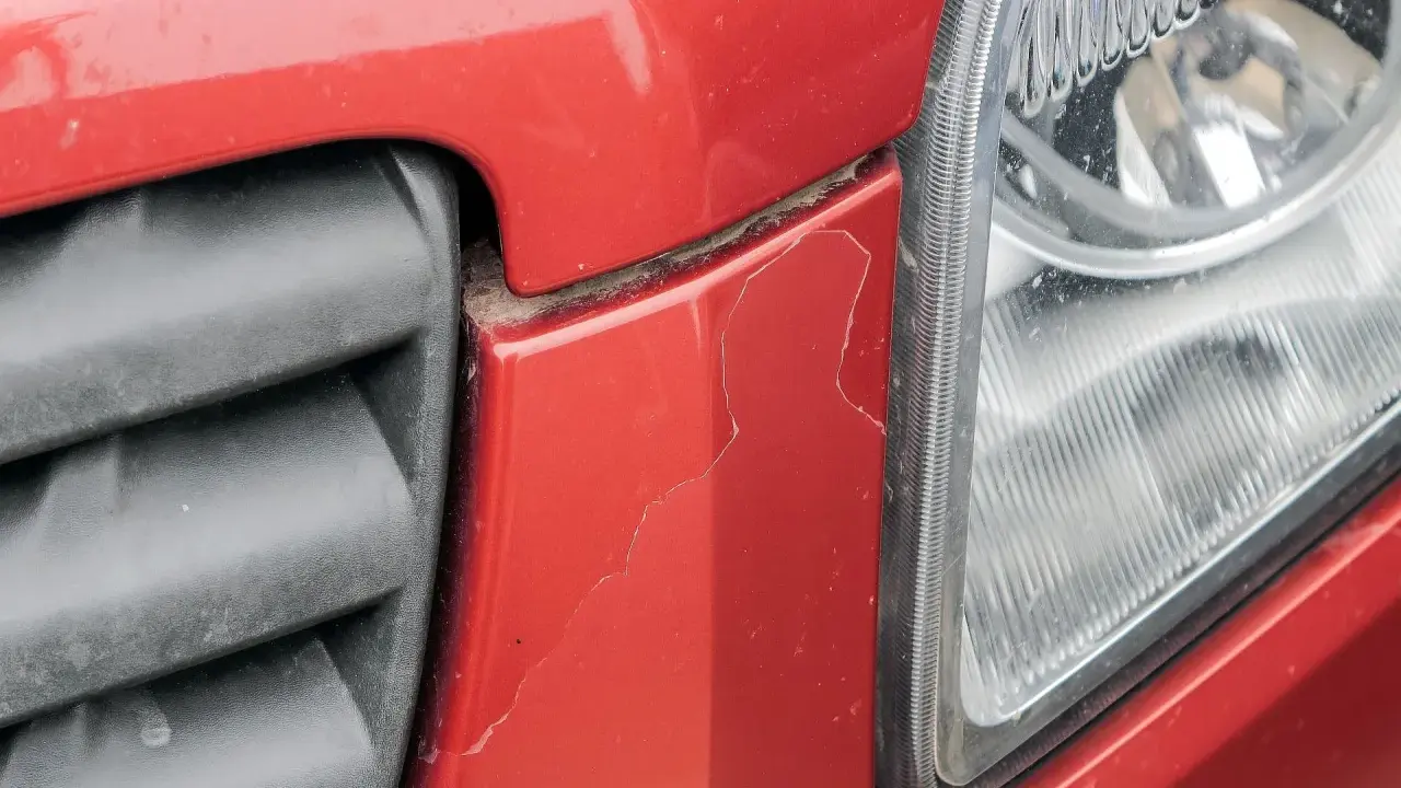 Pęknięty czerwony zderzak obok reflektora. Czas sprawdzić malowanie zderzaka cena.