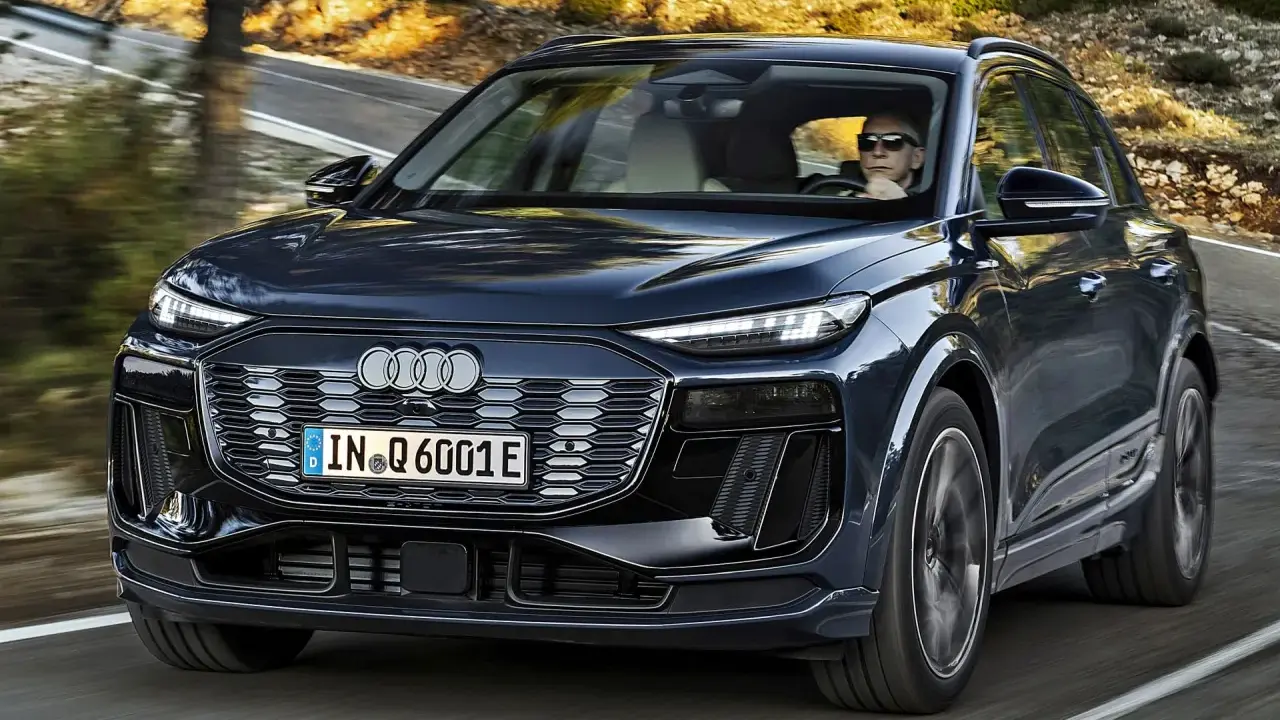 Ciemnogranatowy Audi Q6 e-tron jedzie po krętej drodze. Sprawdź atrakcyjną audi q6 e-tron cenę.