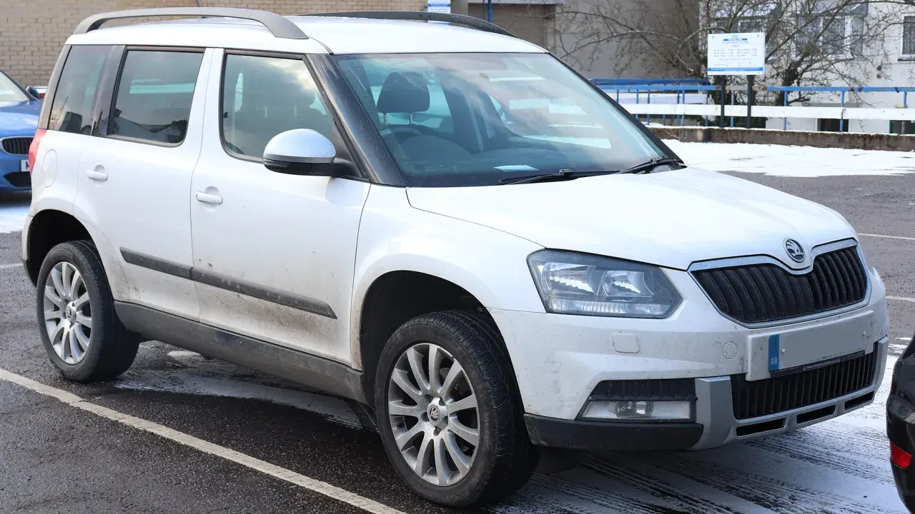 Biały Skoda Yeti na parkingu. Wiele osób chwali sobie ten model, a opinie o nim są zazwyczaj pozytywne.