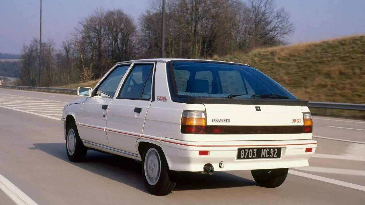 Biały Renault 11 90 GT z lat 80. jedzie autostradą.