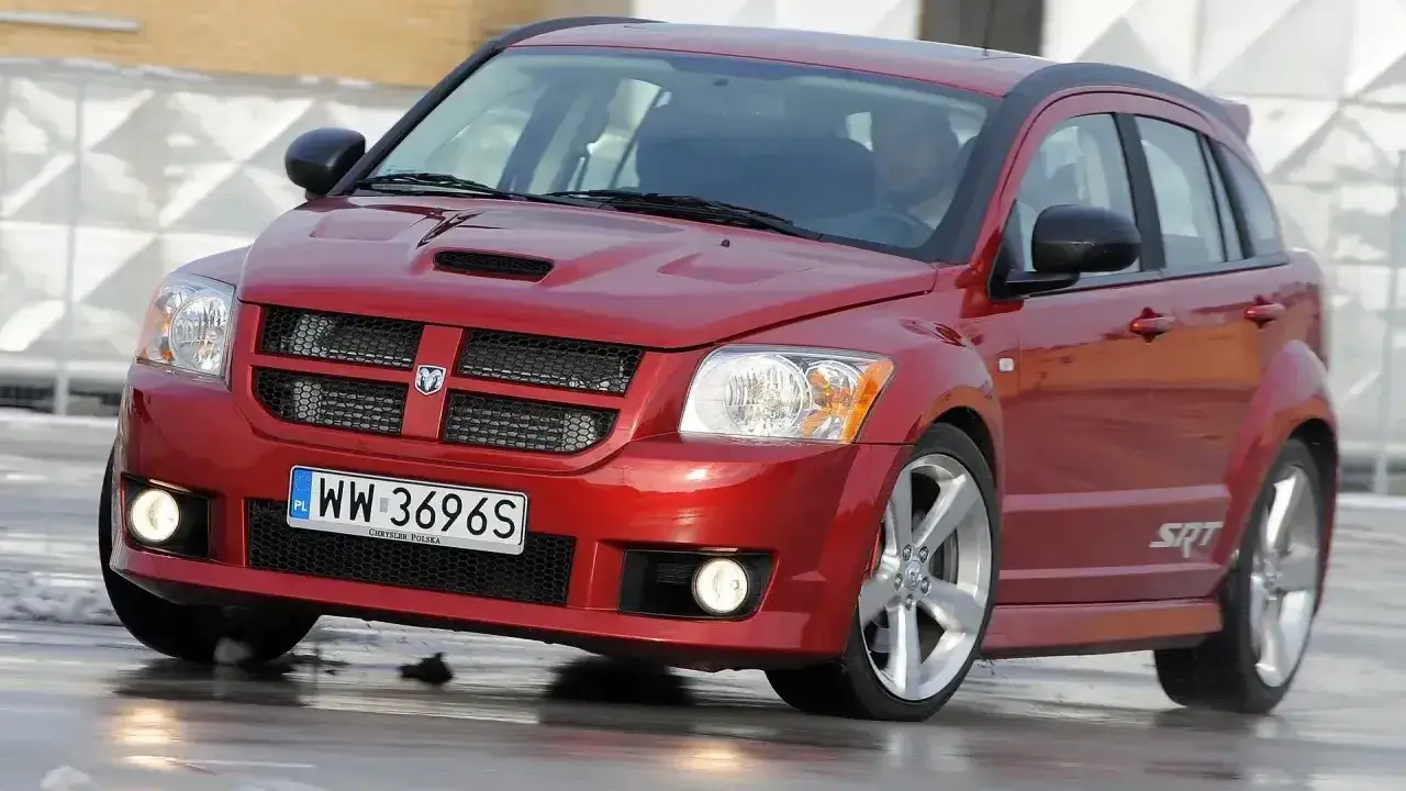 Czerwony Dodge Caliber SRT na mokrej nawierzchni. Wiele osób szuka **dodge caliber opinie** przed zakupem.