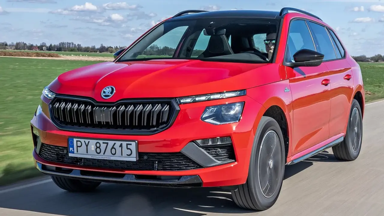 Czerwona Skoda Kamiq w ruchu, idealna na wakacyjne wyjazdy. Sprawdź atrakcyjną skoda kamiq cena.