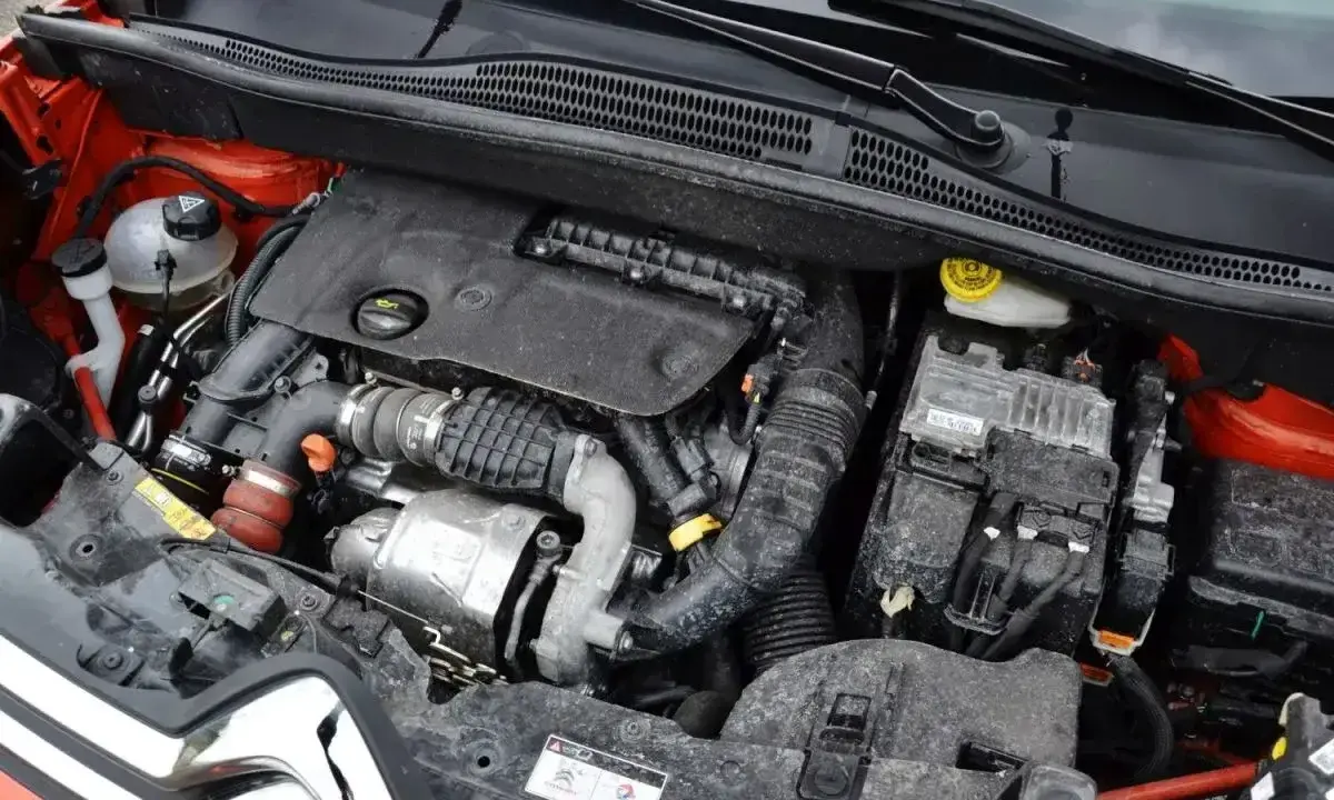 Silnik 1.6 HDI w samochodzie, widoczne elementy układu dolotowego, turbosprężarka i skrzynka bezpieczników.