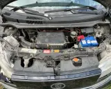 Silnik 1.6 VVT-i w Daihatsu Materia, z widocznym akumulatorem Varta i elementami układu chłodzenia.