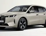 Elegancki, beżowy BMW iX z nowoczesnym grillem i smukłymi światłami.