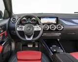 Wnętrze Mercedesa GLA 200 z czerwono-czarną tapicerką, nowoczesnym kokpitem i ekranem nawigacji.
