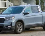 Szary Honda Ridgeline stoi przed domem.