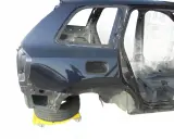 Tylna część nadwozia Volvo XC90 w kolorze granatowym, bez szyb i wnętrza, na żółtym wózku.