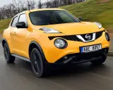Żółty Nissan Juke 1.6 benzyna w ruchu ulicznym.