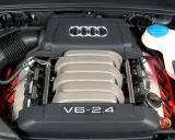 Silnik V6 2.4 z Audi C6. Widoczne logo Audi i elementy układu zapłonowego.