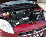 Czerwony Fiat Bravo 1.4 T-Jet z otwartą maską, widoczny silnik i reflektor.