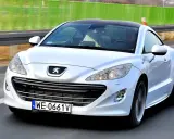 Biały Peugeot RCZ, jeden z francuskich marek samochodów, pędzi po autostradzie.