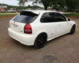 Białe Honda Civic EK9 Type R z czarnymi felgami i spojlerem, gotowe do jazdy.