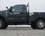 Ciemnozielony Ford F350 z zabudową serwisową, numerem SL-20010 i oponami Cooper Discoverer STT Pro.