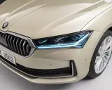 Nowy Skoda Superb 2024 w beżowym kolorze, z charakterystycznym grillem i nowoczesnymi światłami LED.