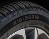 Zbliżenie na oponę z widocznym rozmiarem 215/55R18. Data produkcji opony jest kluczowa dla jej bezpieczeństwa.