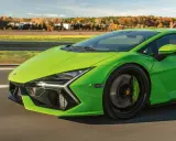 Jaskrawozielony Lamborghini Revuelto pędzi po drodze, ukazując swoje futurystyczne linie i sportowe detale.