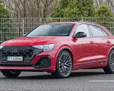 Czerwony Audi RS Q8 z czarnymi felgami stoi na parkingu.
