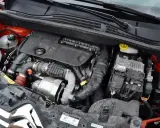Silnik 1.6 HDI w samochodzie, widoczne elementy układu dolotowego, turbosprężarka i skrzynka bezpieczników.
