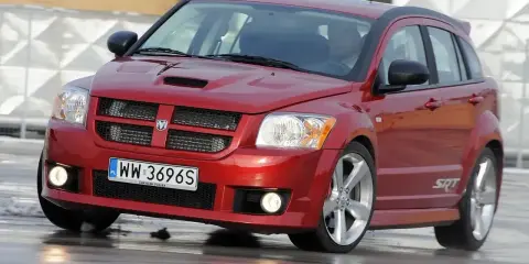 Czerwony Dodge Caliber SRT na mokrej nawierzchni. Wiele osób szuka **dodge caliber opinie** przed zakupem.