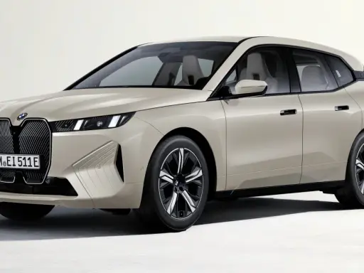 Elegancki, beżowy BMW iX z nowoczesnym grillem i smukłymi światłami.