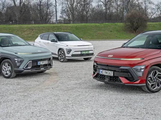 Trzy nowe Hyundai w różnych kolorach: zielony, biały i czerwony, zaparkowane na żwirowym placu.