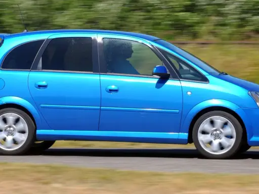 Niebieski Opel Meriva 1.6 benzyna w ruchu, z rozmytym tłem.