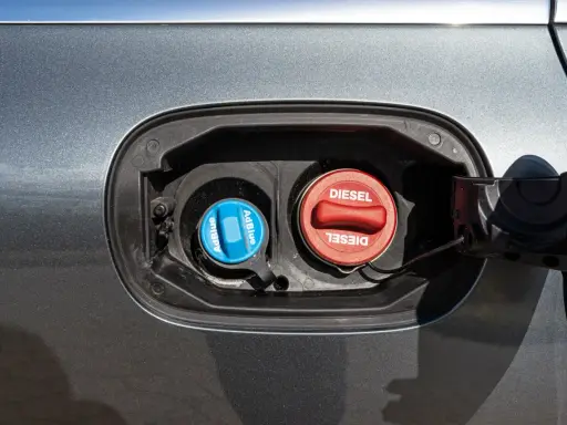 Dwa korki wlewu paliwa: czerwony z napisem DIESEL i niebieski z napisem AdBlue. AdBlue to płyn stosowany w nowoczesnych dieslach.