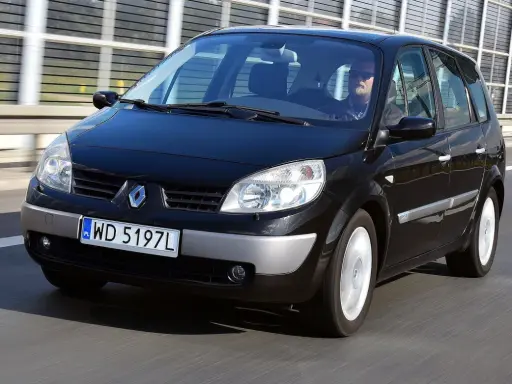 Czarny Renault Scenic 2 1.6 16v jedzie autostradą. Kierowca w okularach przeciwsłonecznych prowadzi auto.