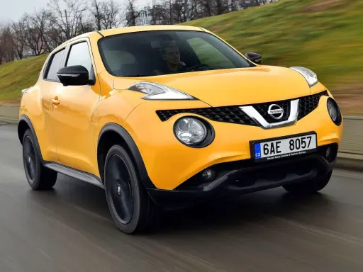 Żółty Nissan Juke 1.6 benzyna w ruchu ulicznym.