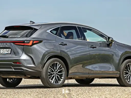 Szary Lexus NX 350h na tle pola rzepaku. Sprawdź, jaka jest aktualna lexus nx 350h cena i wybierz swój wymarzony SUV.