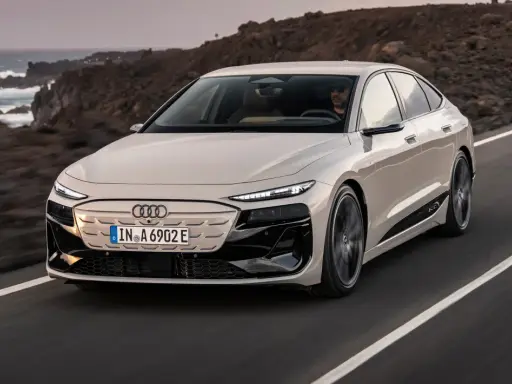 Eleganckie Audi A6 e-tron sunie po malowniczej drodze nad oceanem.