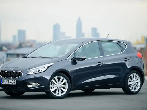Ciemnoszary Kia Ceed 1.6 benzyna stoi na tle miejskiego krajobrazu.