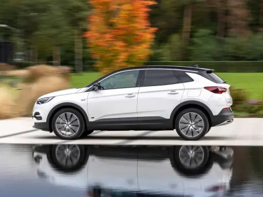 Biały Opel Grandland w ruchu, z refleksami na wodzie. Sprawdź aktualną opel grandland cena i wybierz swój wymarzony SUV.
