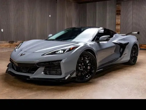Szary Chevrolet Corvette C8, jeden z najnowszych chevrolet modele, prezentuje się dynamicznie na tle nowoczesnego wnętrza.