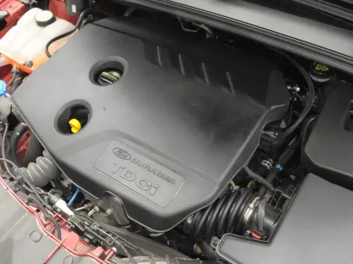 Silnik Ford Focus MK3 1.6 TDCI. Widoczna czarna osłona silnika z napisem "Ford Duratorq TDCI".