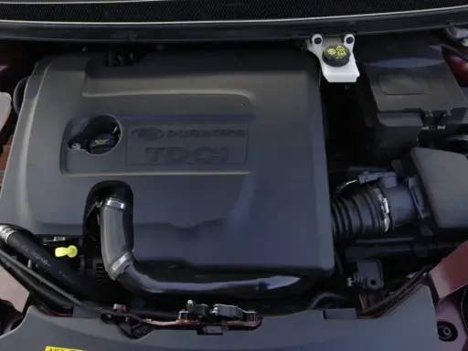 Silnik Ford Focus MK2 1.6 TDCI. Widoczna czarna osłona silnika z napisem "DURATORQ TDCI".