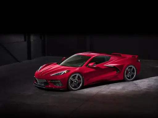 Czerwony Chevrolet Corvette C8 w ciemnym pomieszczeniu. Marzysz o tym aucie? Sprawdź corvette c8 cena i spełnij marzenie!