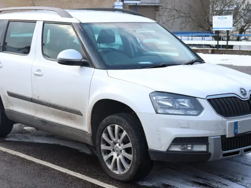 Biały Skoda Yeti na parkingu. Wiele osób chwali sobie ten model, a opinie o nim są zazwyczaj pozytywne.