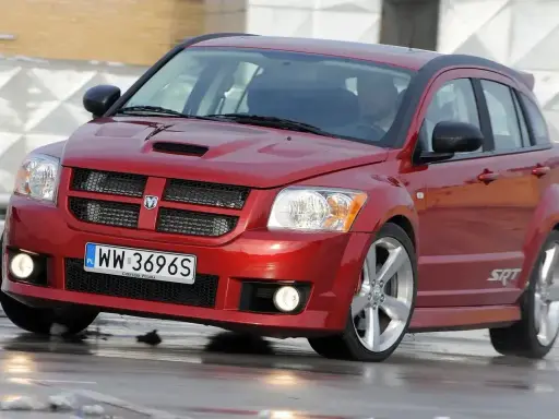 Czerwony Dodge Caliber SRT na mokrej nawierzchni. Wiele osób szuka **dodge caliber opinie** przed zakupem.