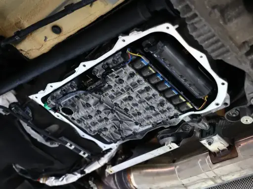Widok od spodu na otwartą skrzynię biegów, gdzie widać skomplikowany mechanizm i cewki odpowiedzialne za płynny powershift.