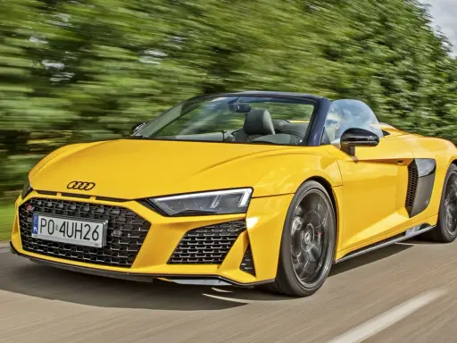Żółty kabriolet Audi R8 pędzi po drodze. Sprawdź aktualną audi r8 cenę i poczuj moc!